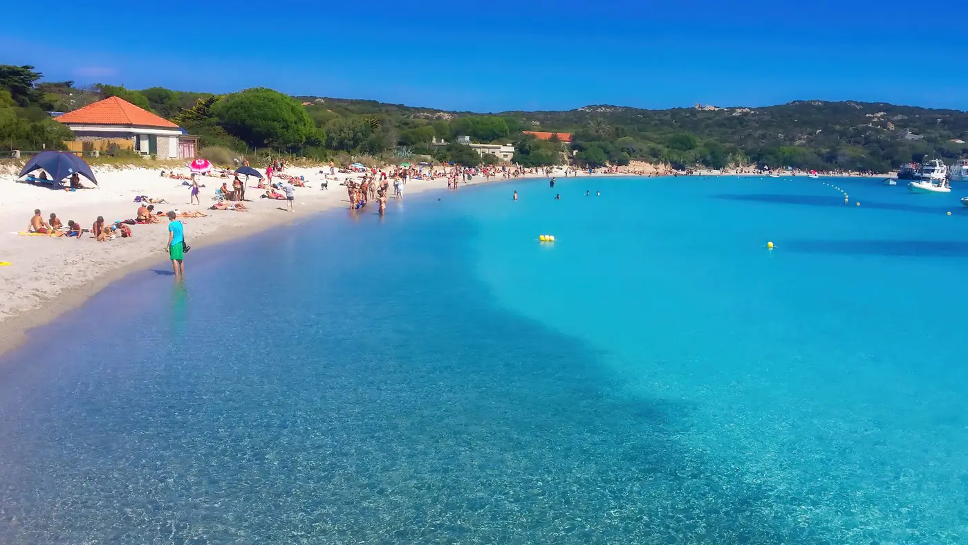 Turquoise waters and sandy shores at La Pelosa Beach, Sardinia capture the essence of summer relaxation.