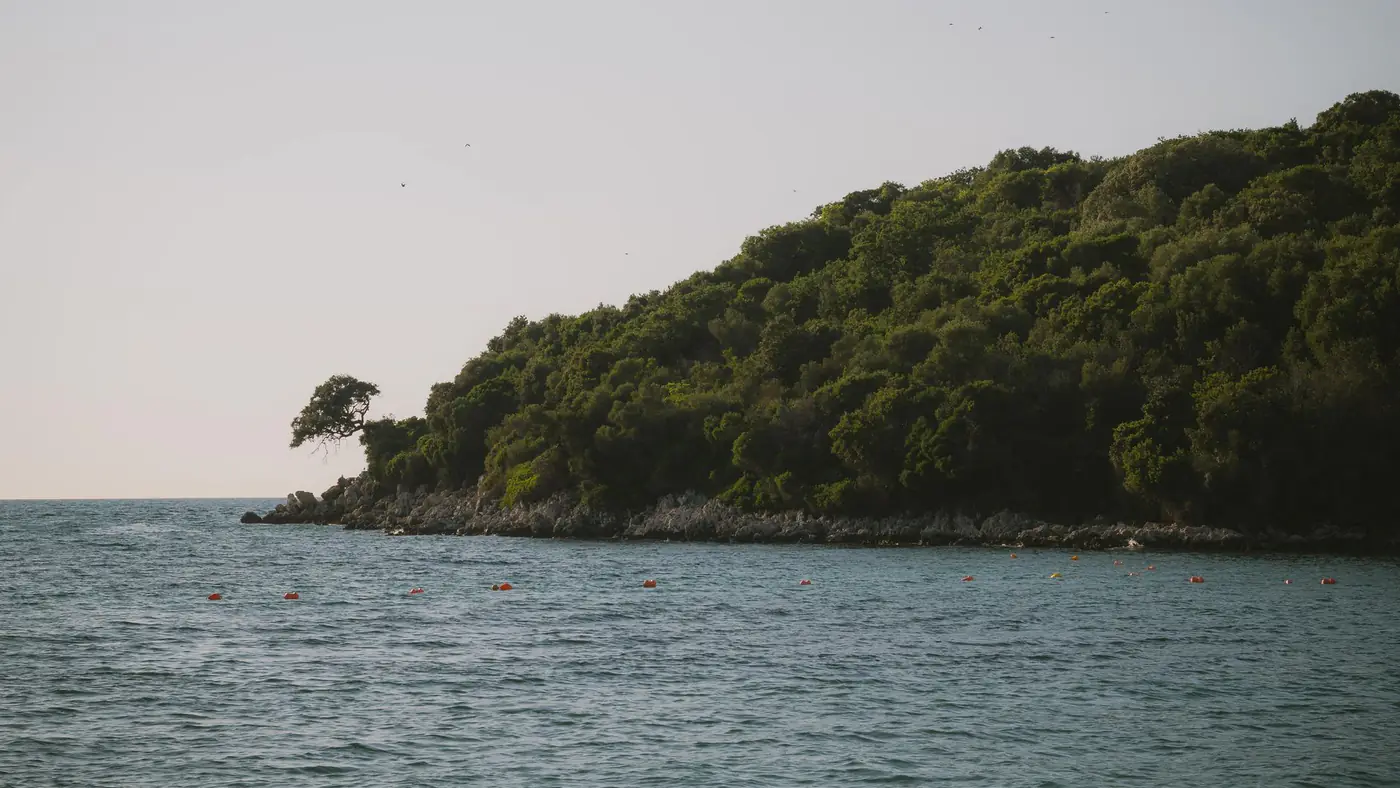 Serene coastal view of Ksamil, Albania with lush greenery and clear waters.