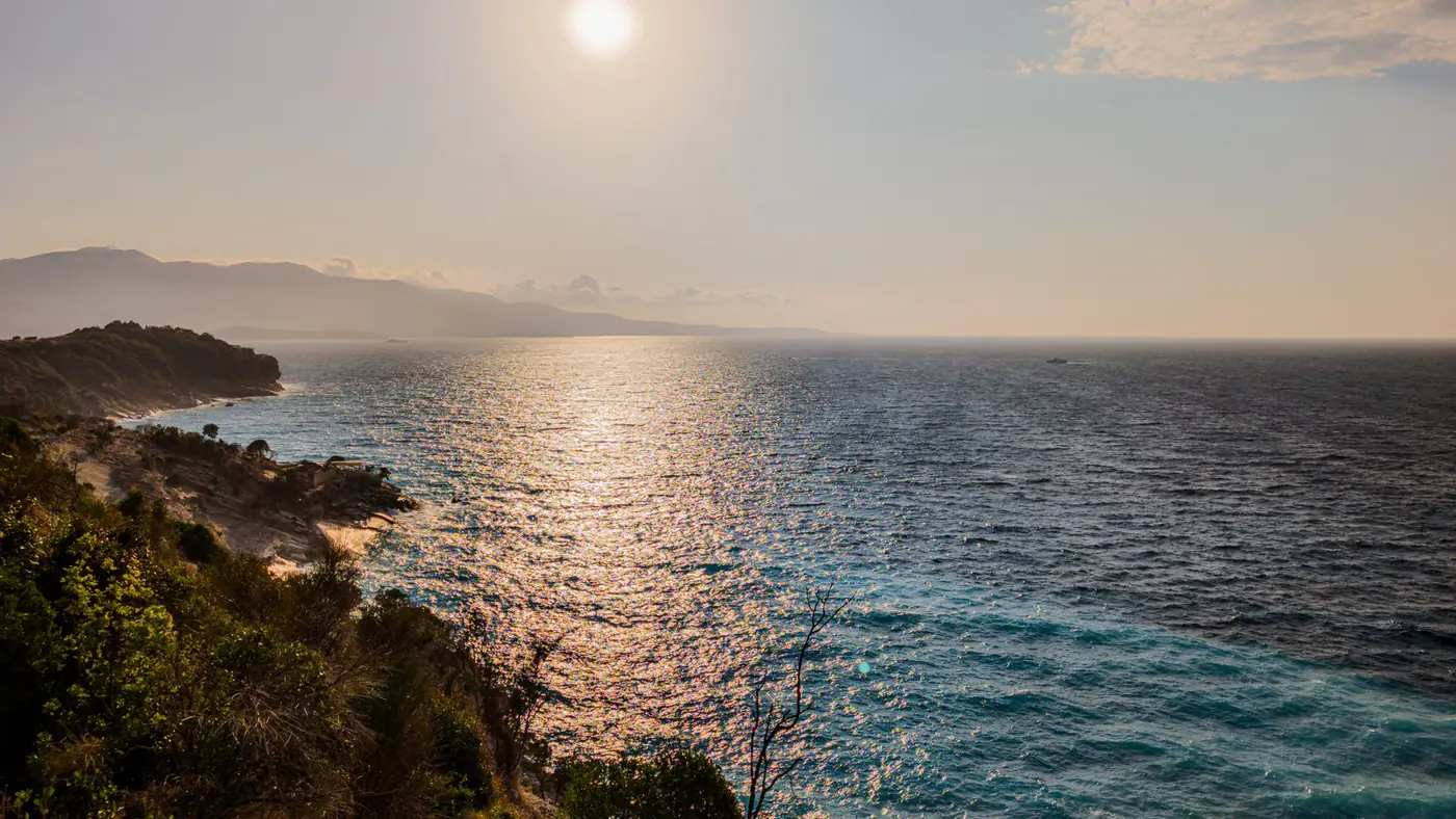 Breathtaking view of a sunset over the Mediterranean Sea in Ksamil, Albania, capturing tranquil waves and vibrant skies.
