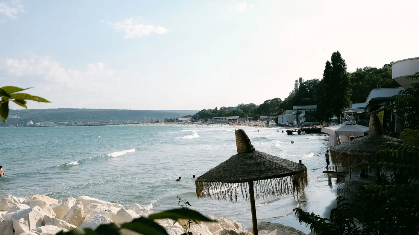 A tranquil beach scene in Bulgaria with umbrellas and clear waters, perfect for holiday relaxation.