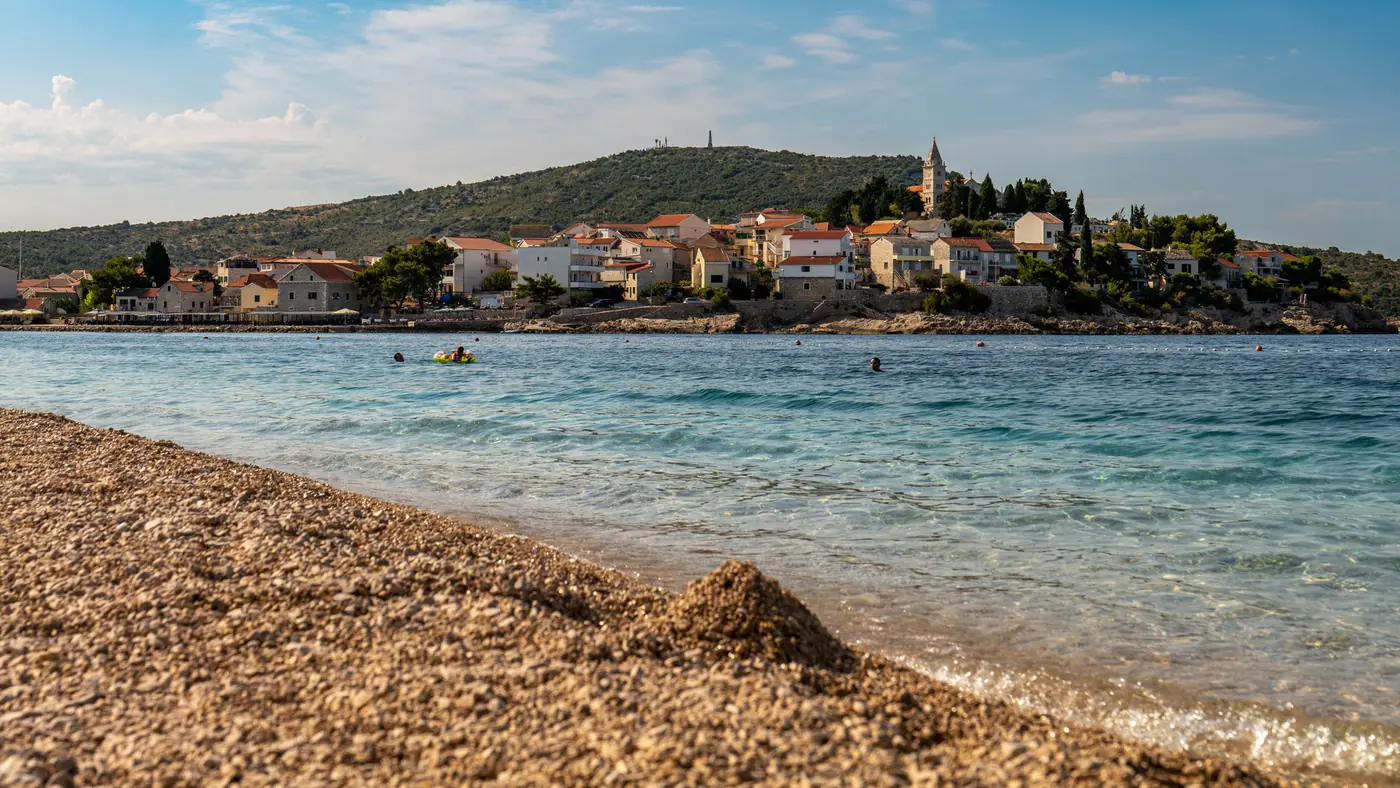 A stunning view of Primošten beach with sparkling waters and charming architecture.