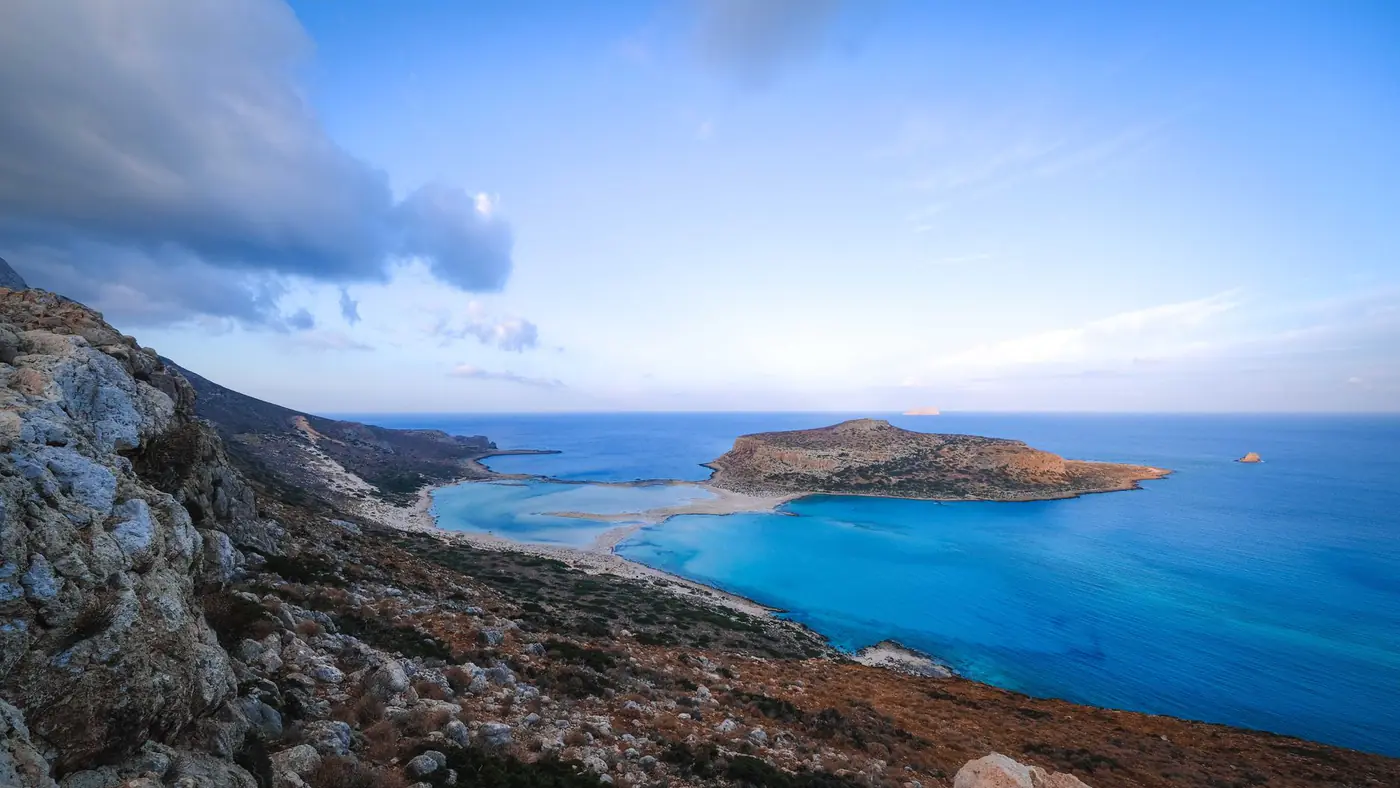 Panoramic view of a serene coastal landscape with turquoise waters and rocky shores.