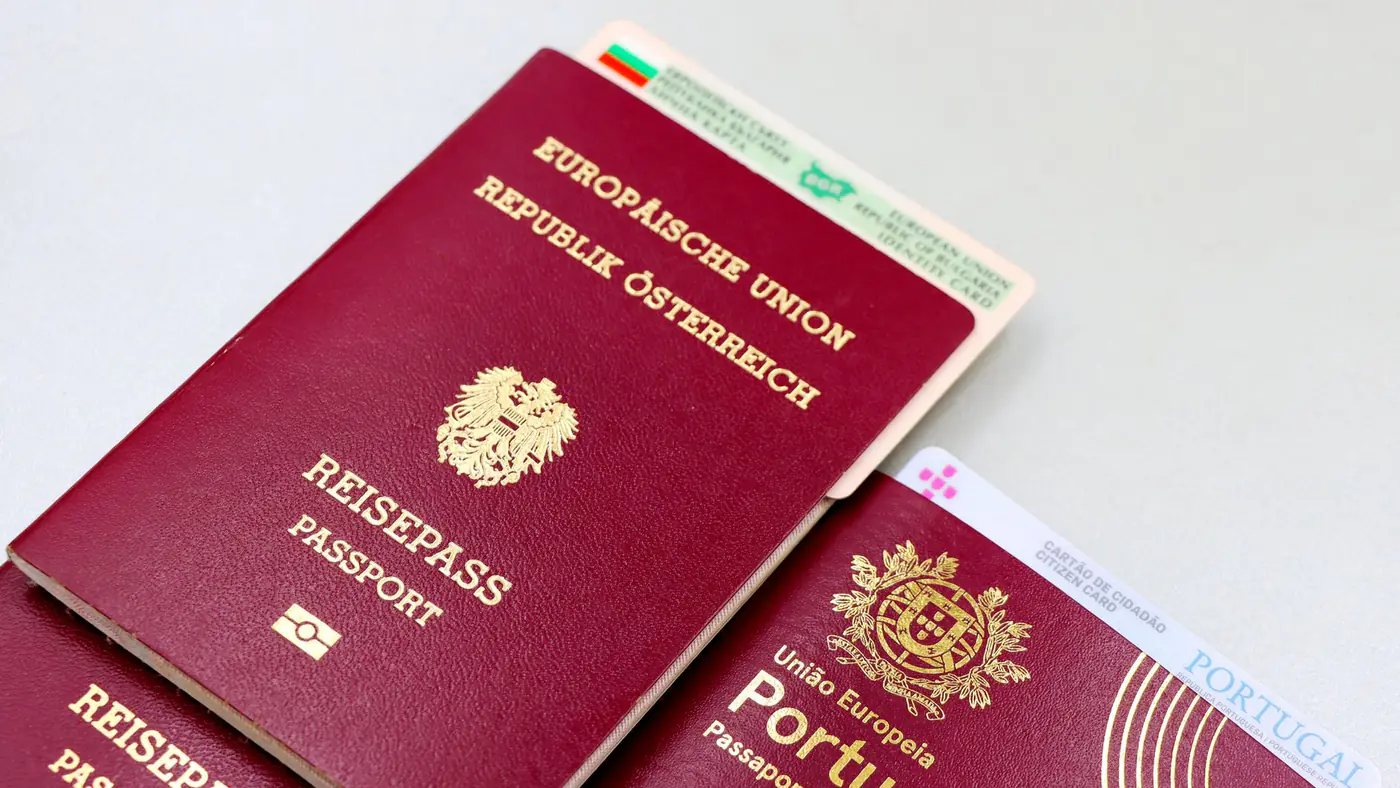 A close-up image of Austrian and Portuguese passports with a Bulgarian ID card.