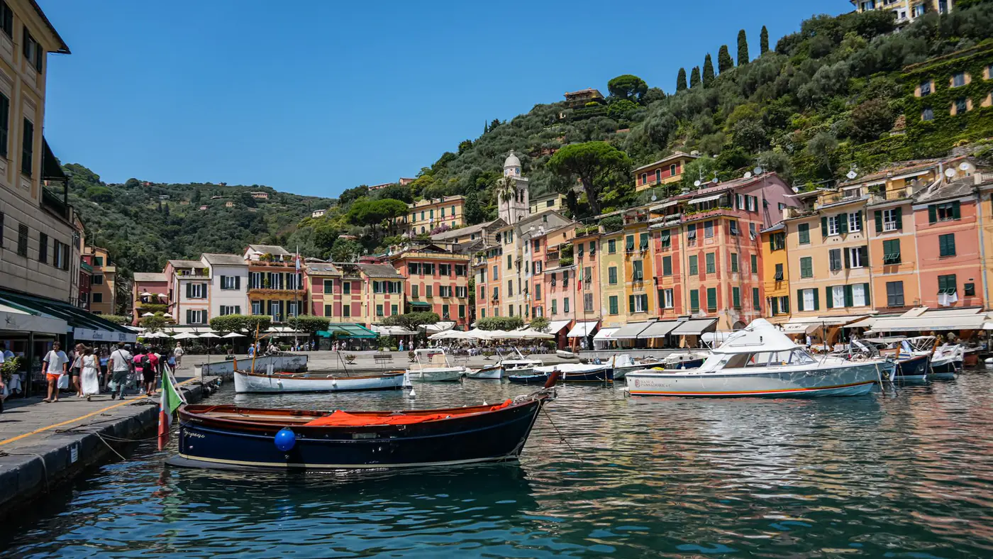 Vibrant Portofino harbor with colorful buildings and boats on a sunny day.