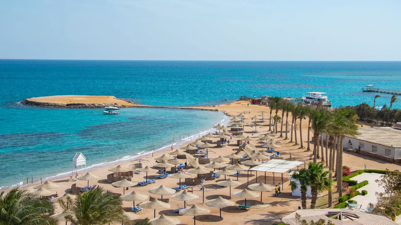 Idyllic beach scene with rows of umbrellas and azure ocean, perfect for travel and relaxation themes.