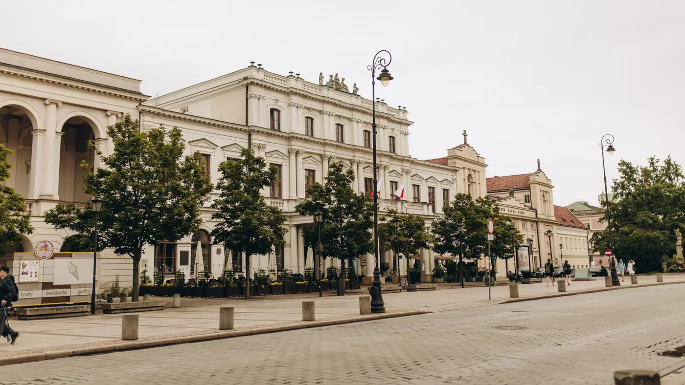 A view of Polonia House on a quiet street in Warsaw, Poland, showcasing historic architecture.