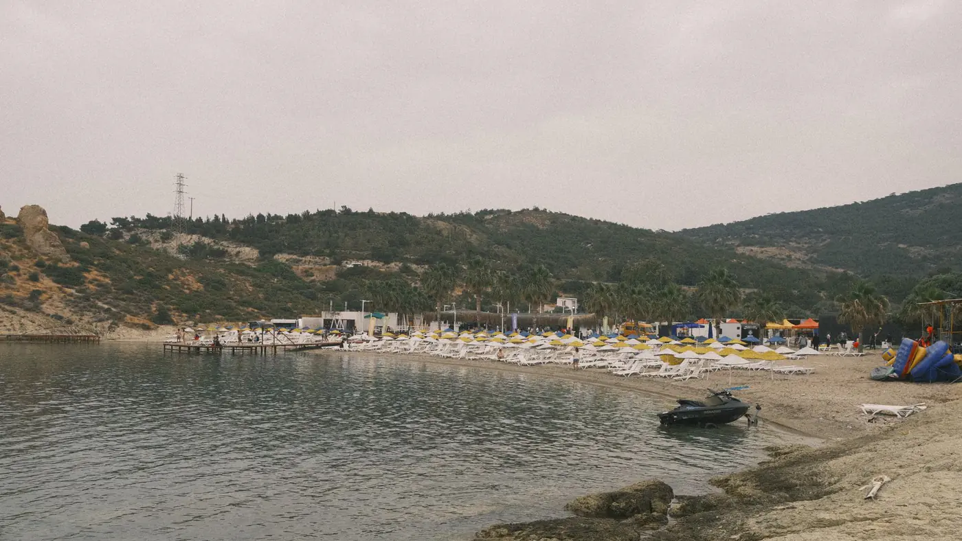 A serene beach with chairs and rocky coastline in Izmir, Turkey.