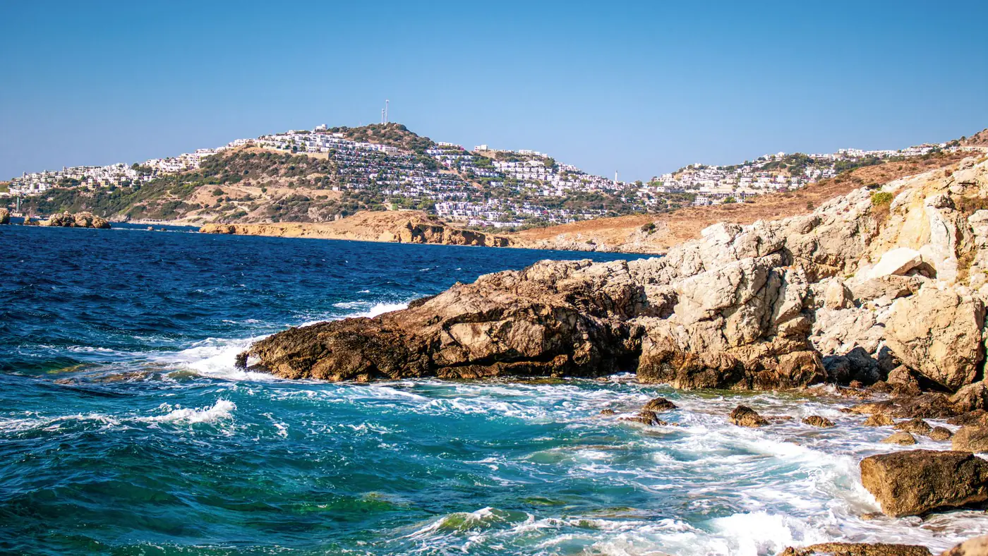 Capture of the stunning Bodrum coastline with clear blue skies and vibrant ocean waves.