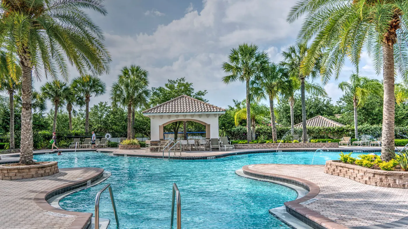 Relaxing tropical poolside scene with palm trees, gazebo, and clear blue water at a luxury resort.
