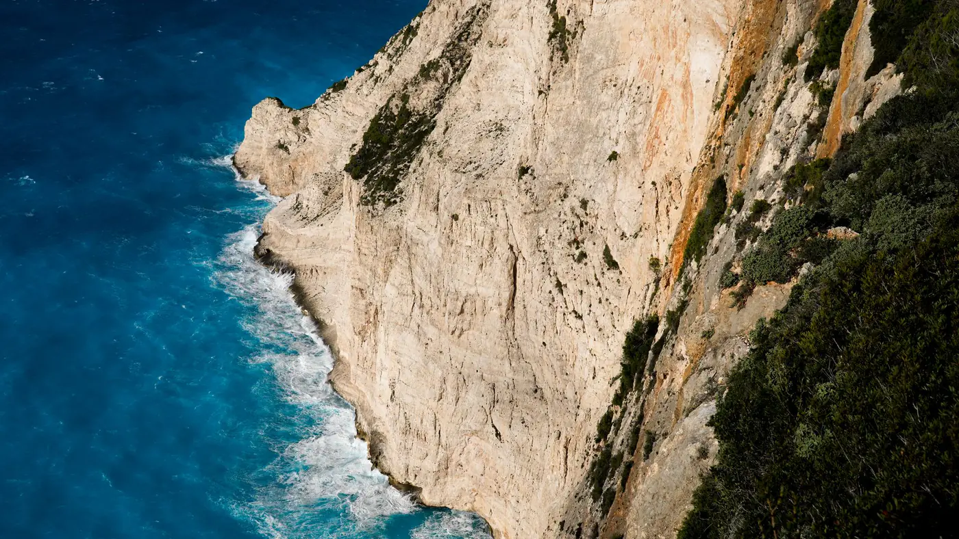 Stunning view of the towering coastal cliffs and vibrant blue sea in Zakynthos, Greece.